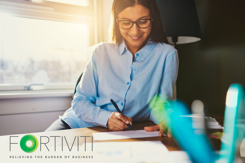 Business woman working at desk writing an address on a envelope